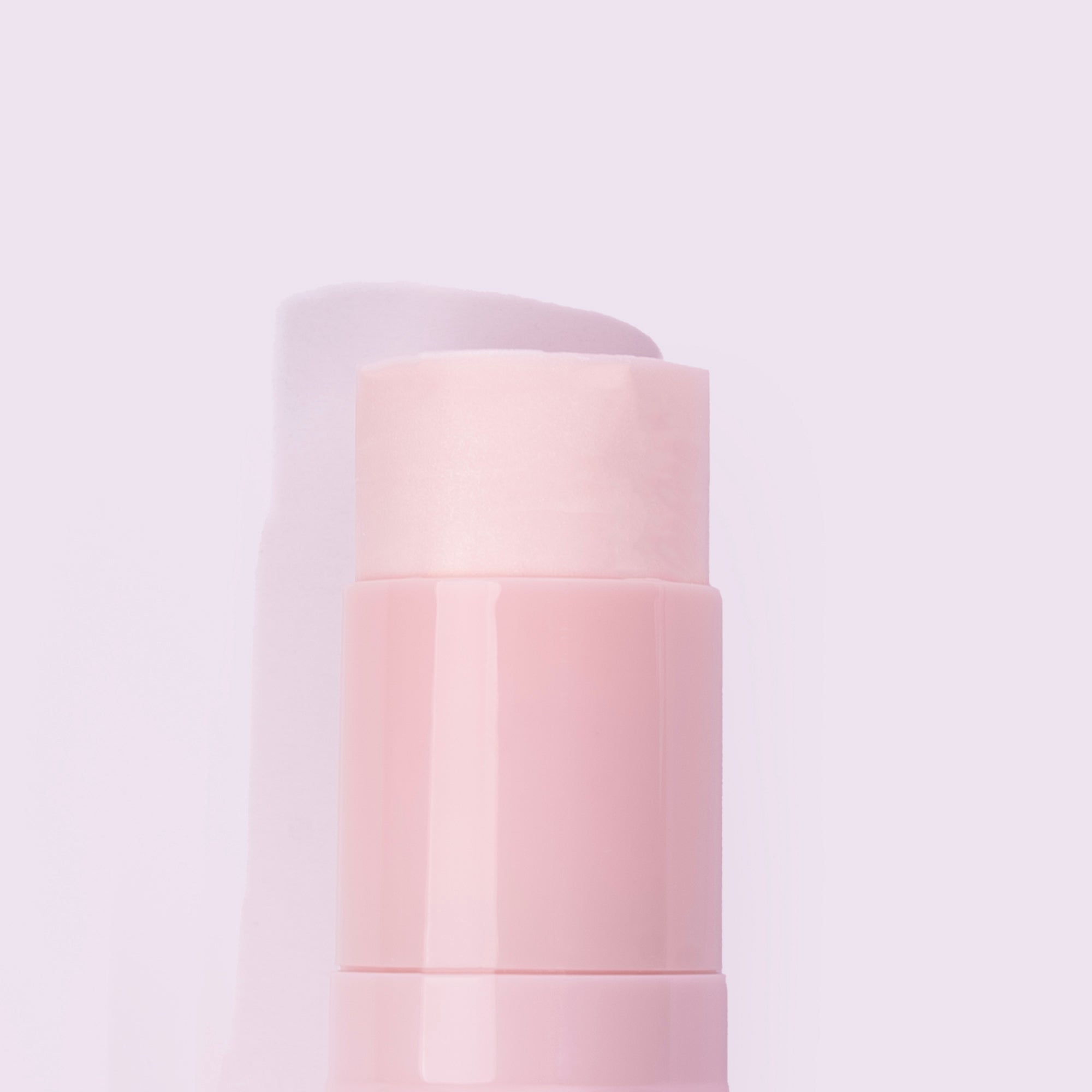 Close-up of a pink cosmetic stick against a light background.