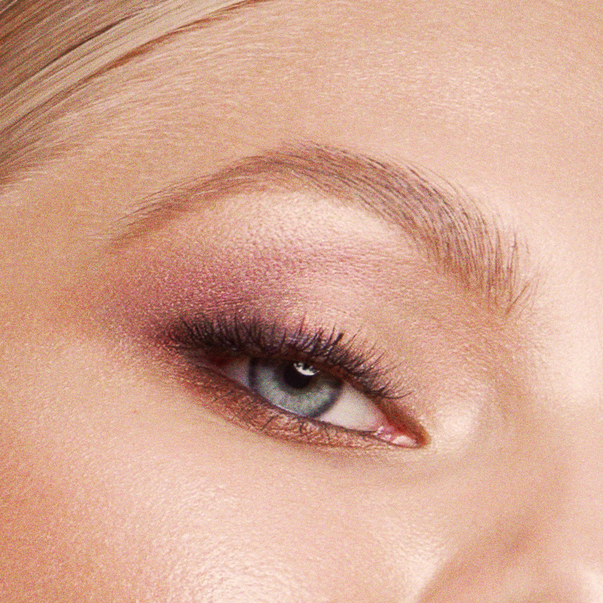 Close-up of a person's eye with pink eyeshadow and mascara