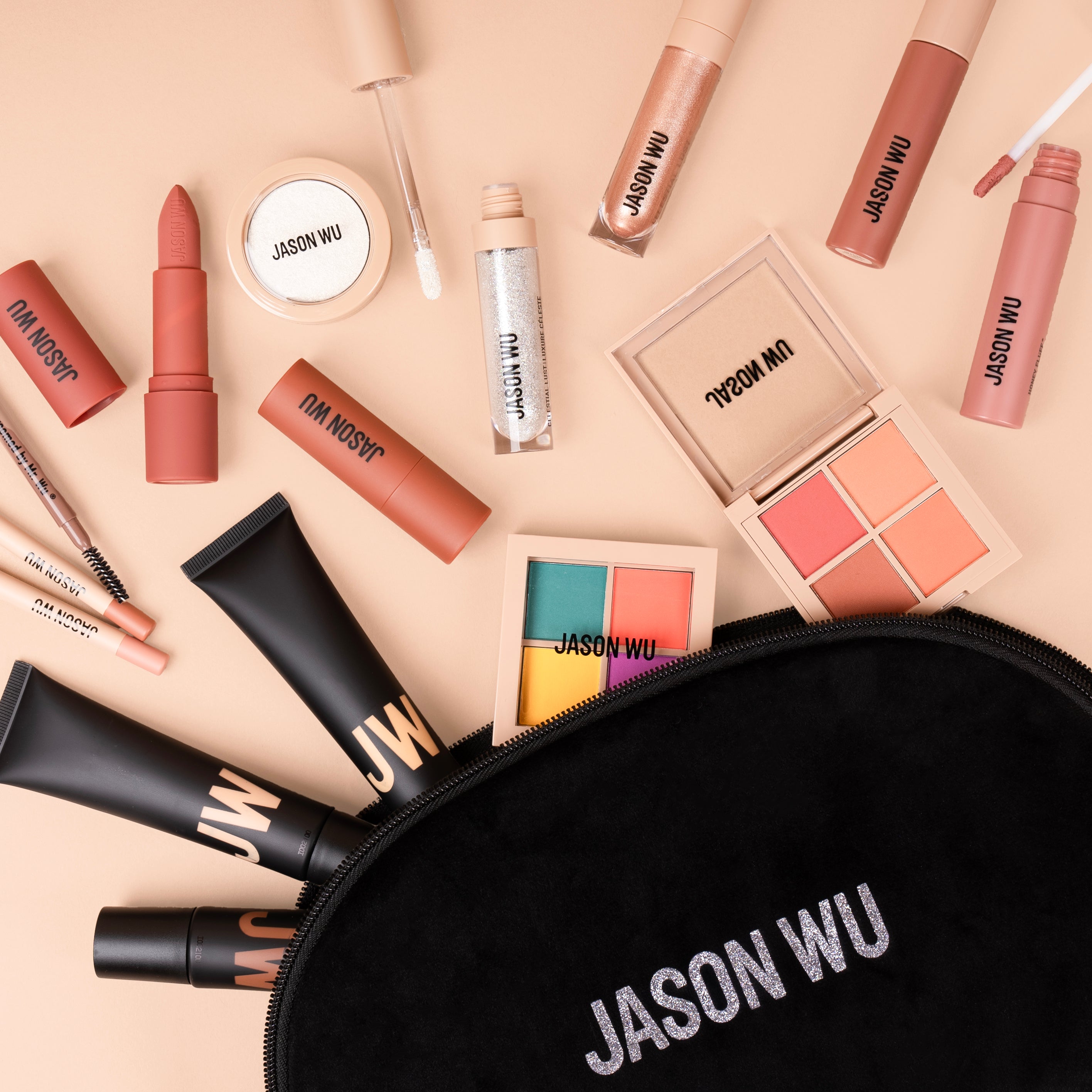 Flat lay of Jason Wu cosmetic products including lipsticks, eyeshadows, and a makeup bag