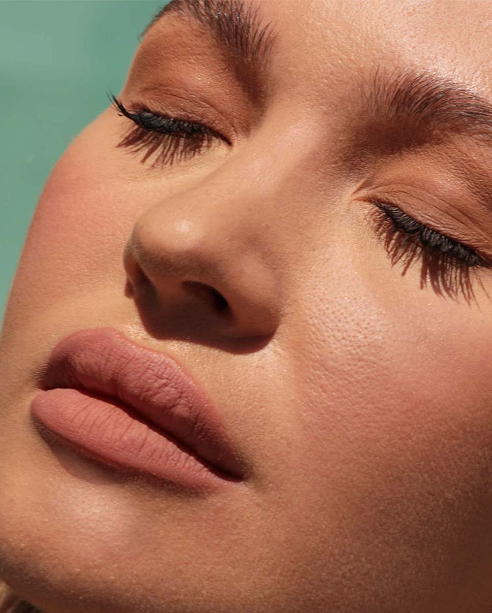 Close-up of a person with closed eyes and natural makeup