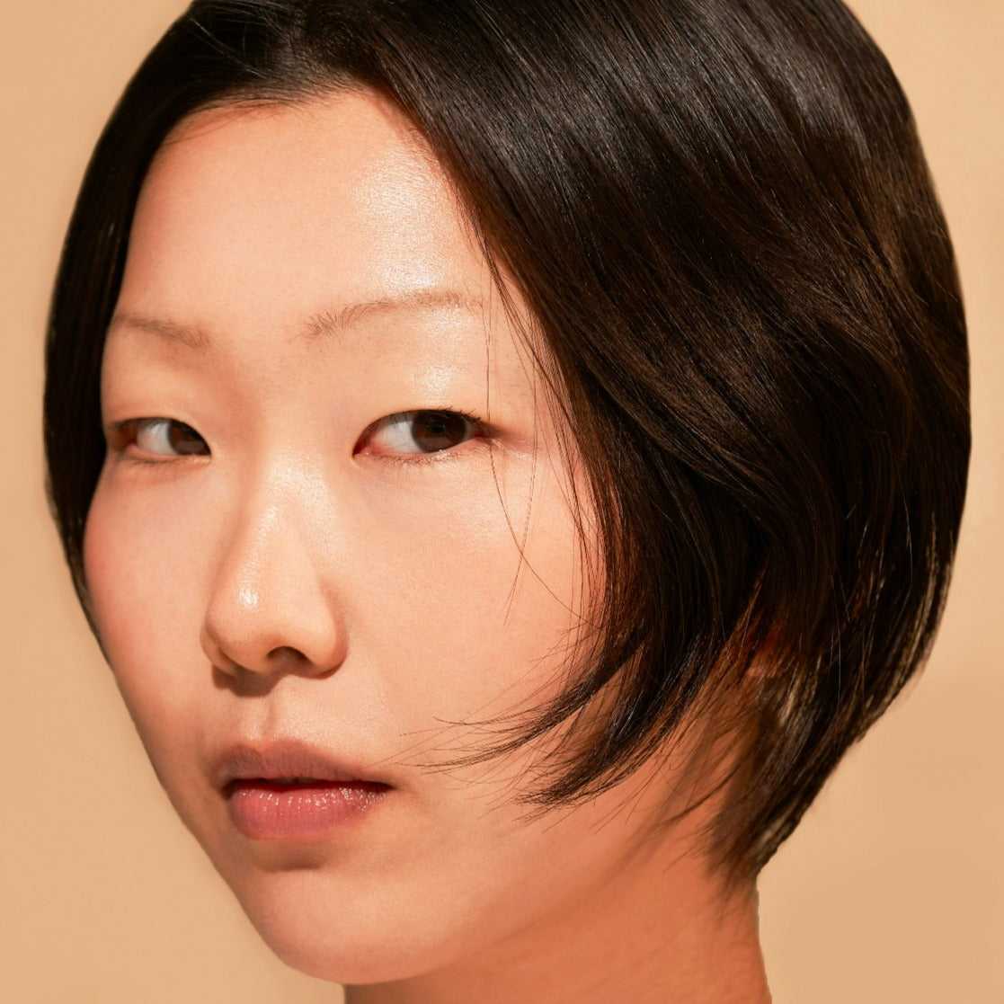 Portrait of a person with short dark hair against a neutral background.