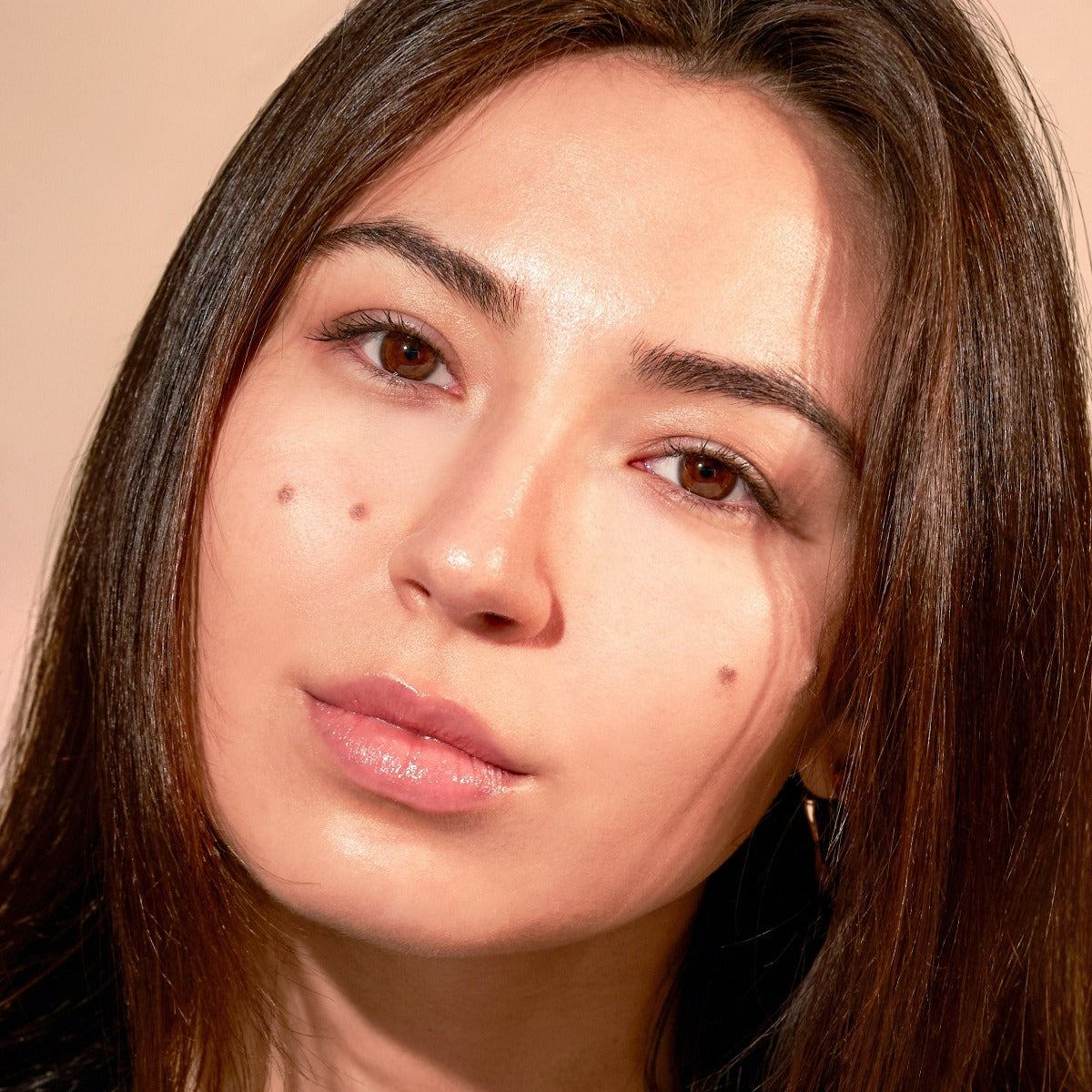 Portrait of a woman with long brown hair and natural makeup.