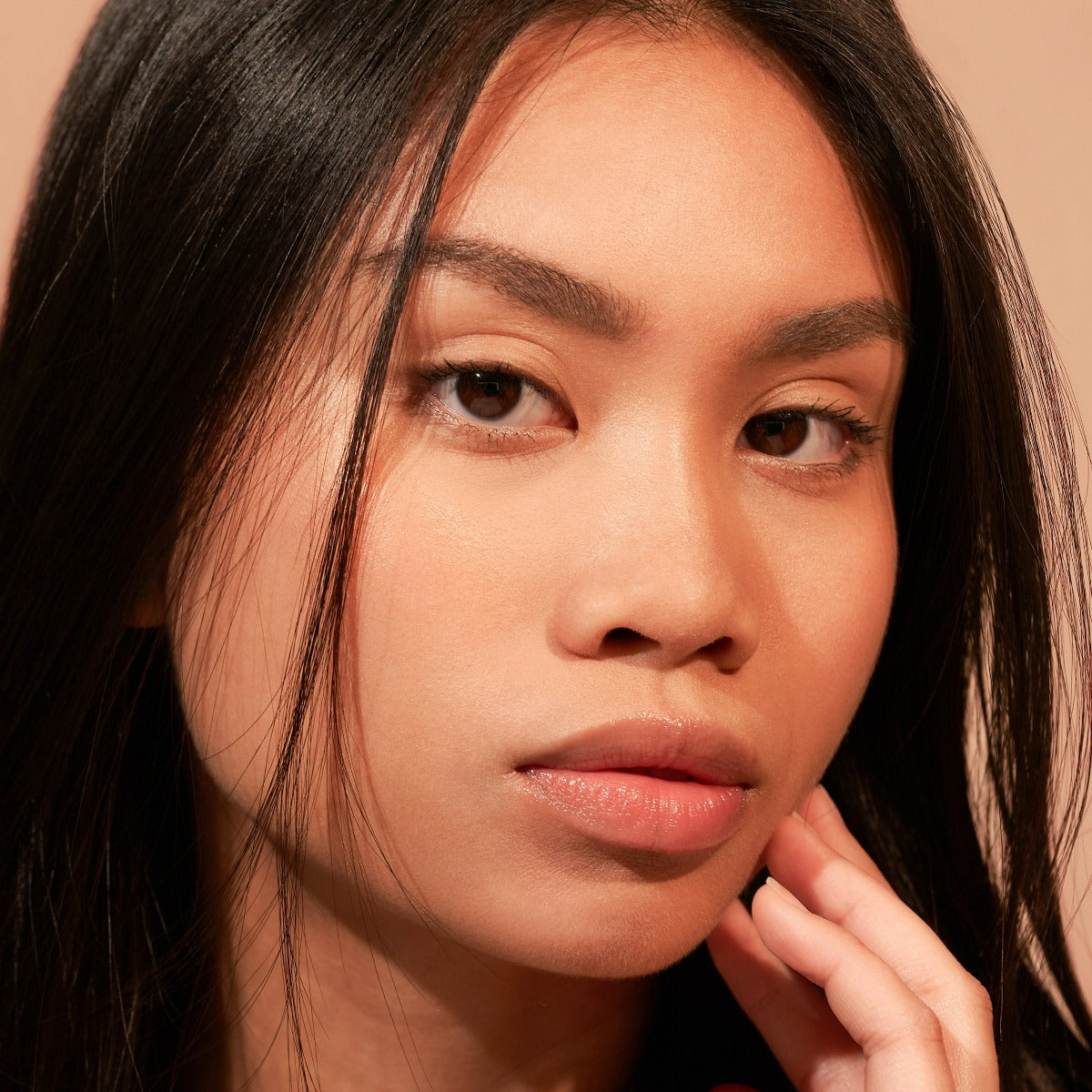 Close-up of a woman with long hair and neutral expression