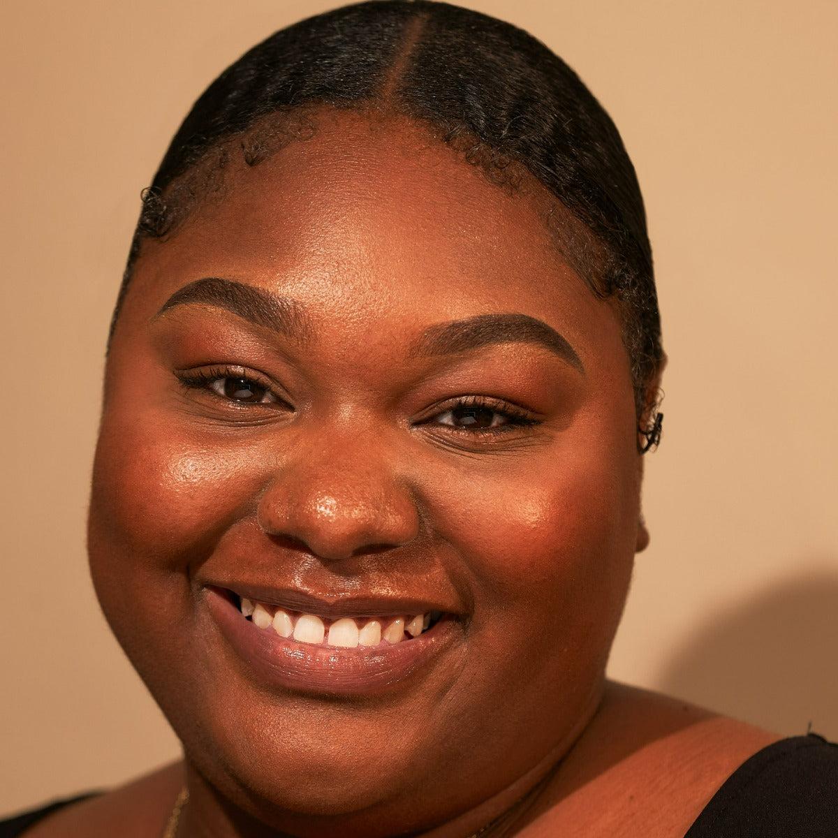 Portrait of a person smiling with a neutral background.